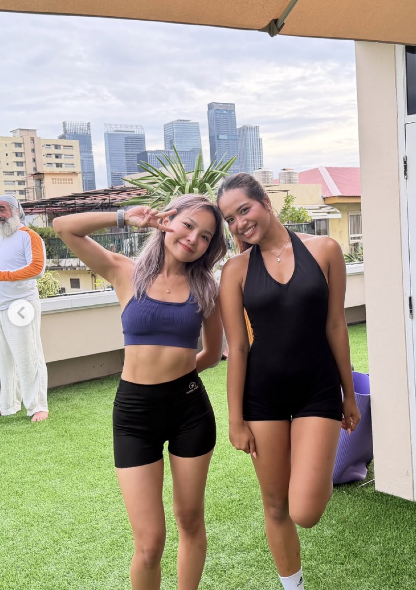 Two friends on the Grove rooftop with the Bangkok skyline behind them